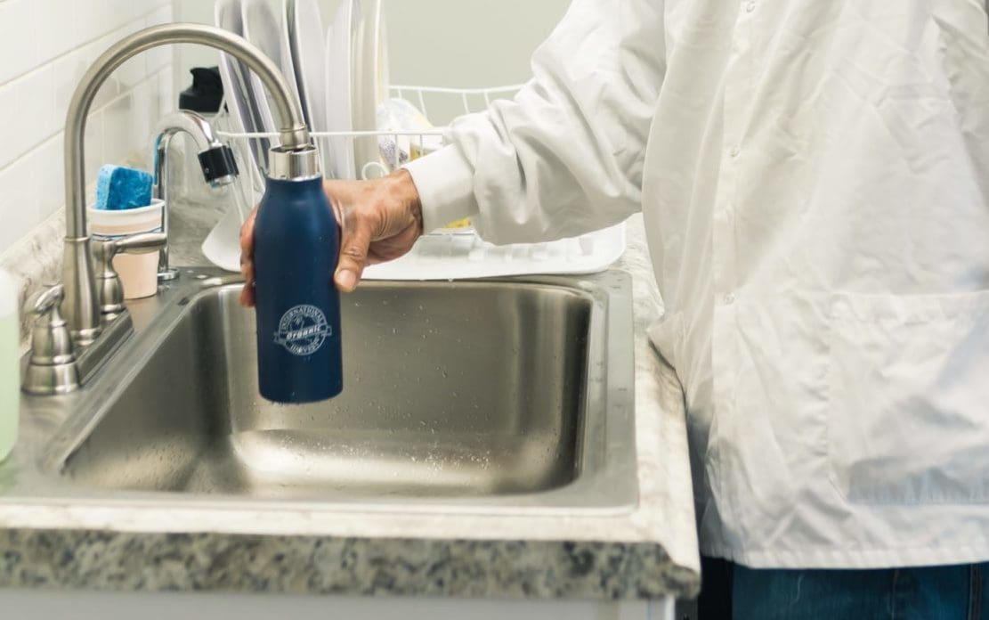 person filling water bottle