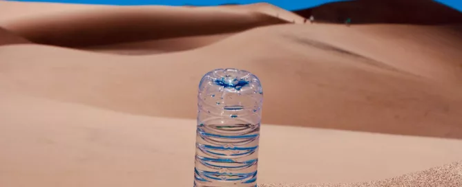 water bottle upside down in the sand