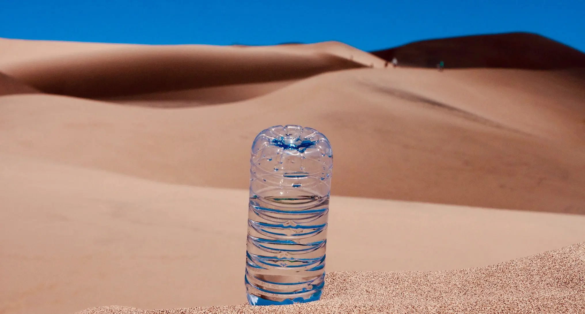 water bottle upside down in the sand