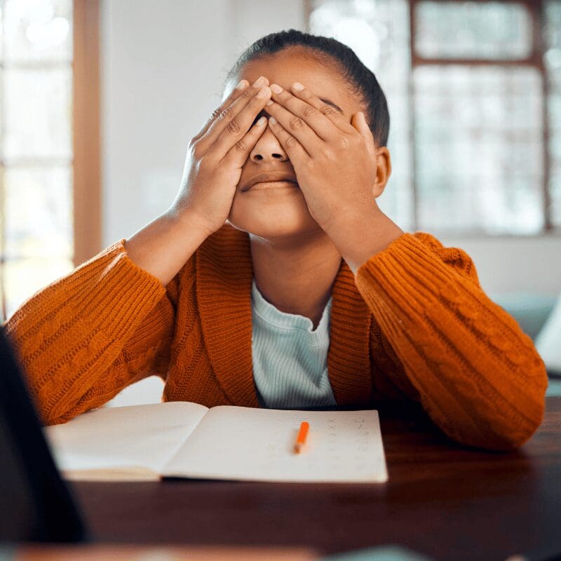 Stressed student covering eyes with hands