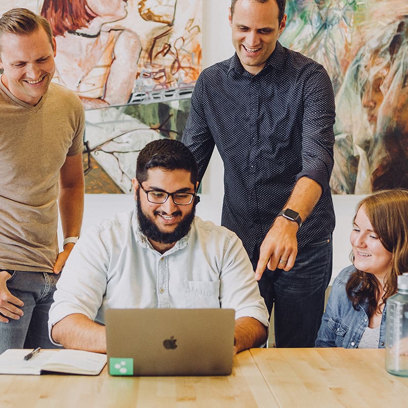 employees gathered around computer