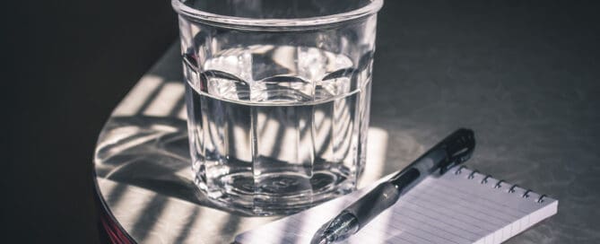 glass of water and notebook
