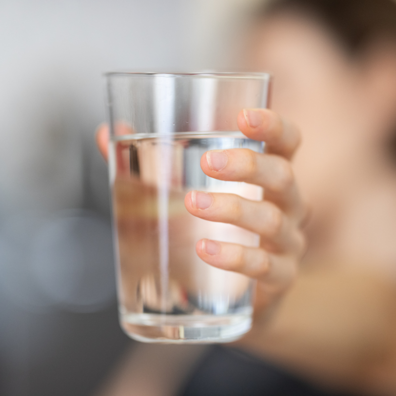 woman holding up a glass of water