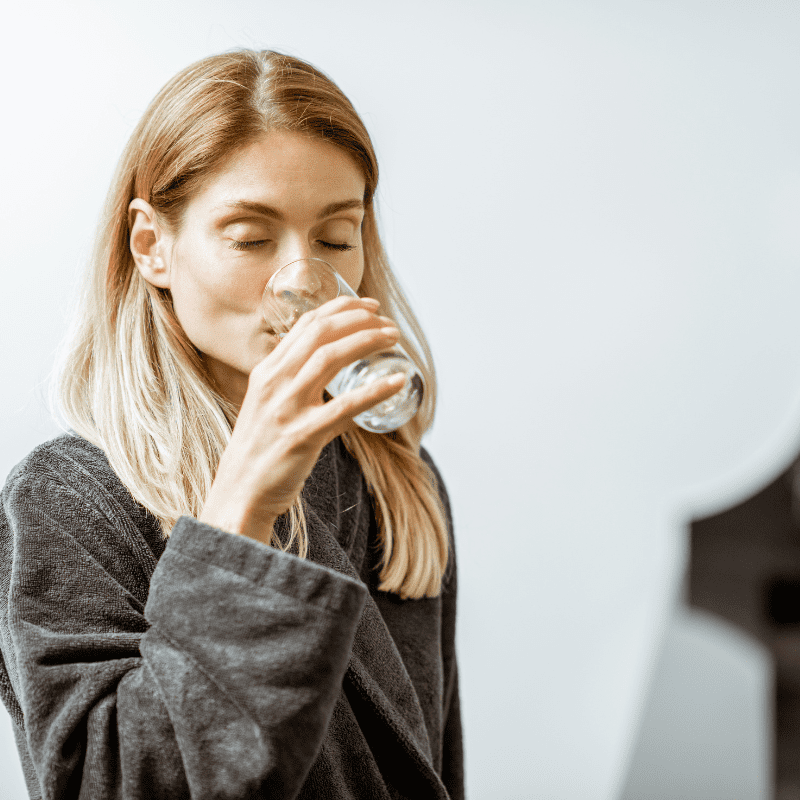 Young woman drinking water from glass