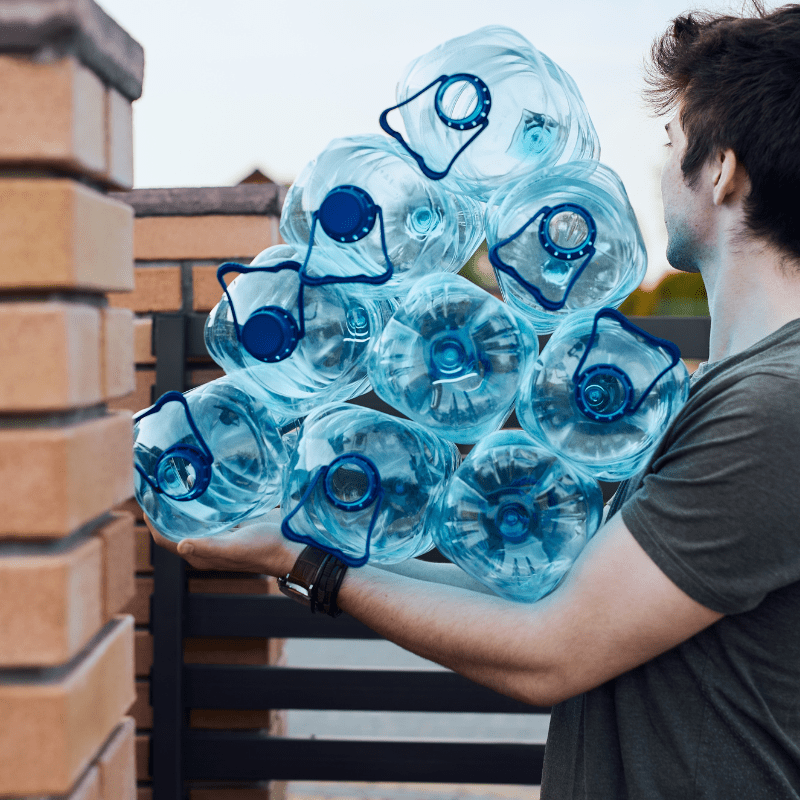 man throwing away empty plastic bottles from office.