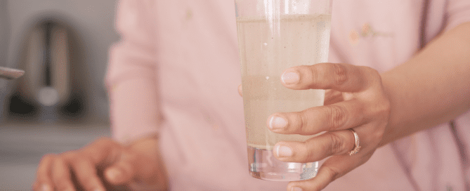 woman holding glass of dirty drinking water