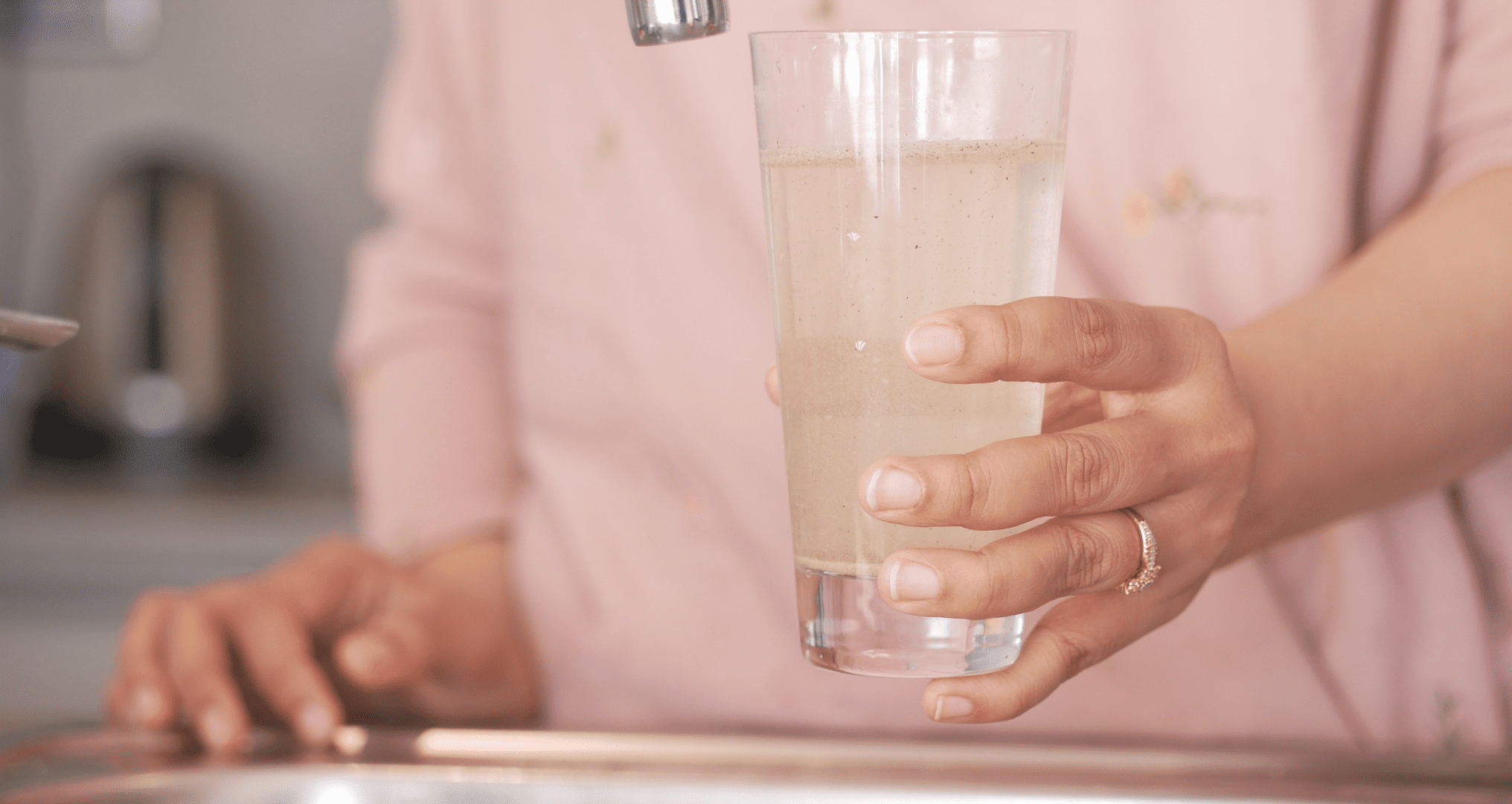 woman holding glass of dirty drinking water