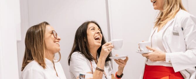 group of female employees laughing and enjoying hot beverages