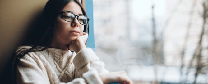 girl with winter blues staring out the window