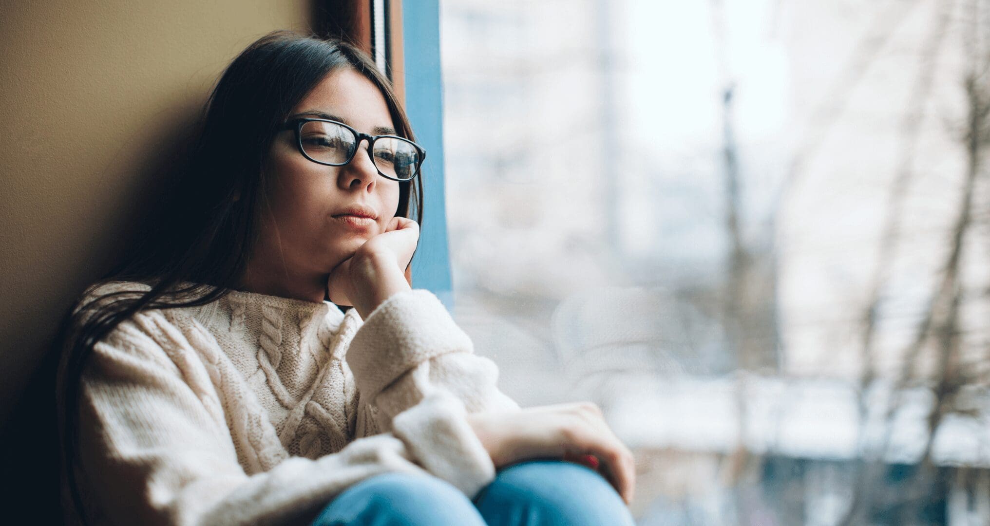 girl with winter blues staring out the window