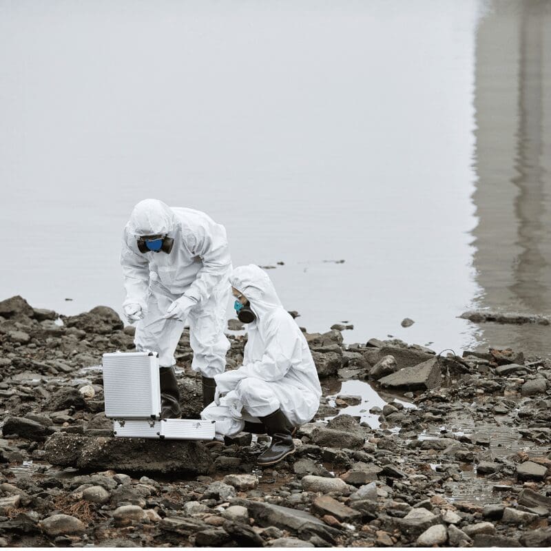 two-workers-at-industrial-disaster-site (2) workers testing for industrial waste in water