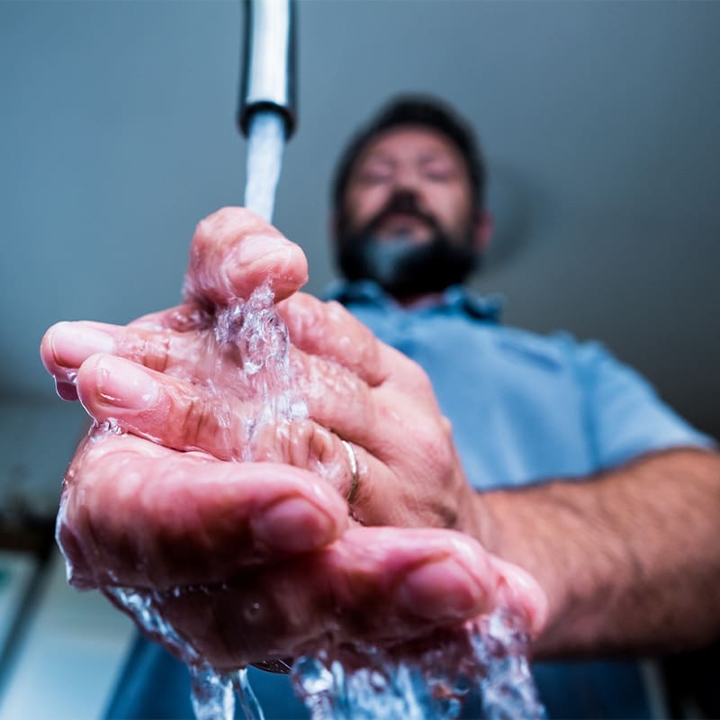 close up of man washing hands at work