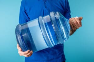 Courier carrying a plastic water jug.