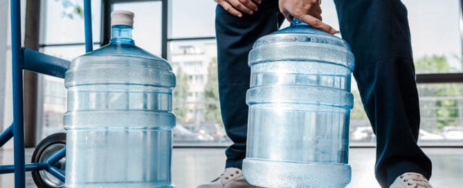 Delivery man dropping off 5-gallon water jugs.