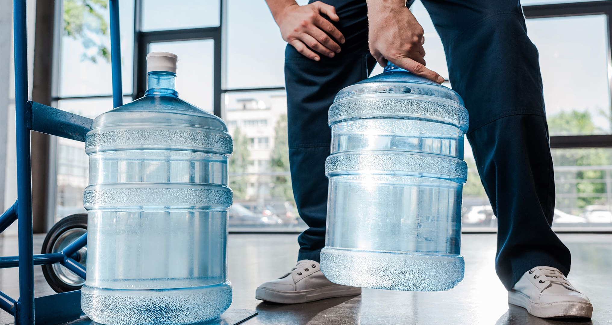 Delivery man dropping off 5-gallon water jugs.