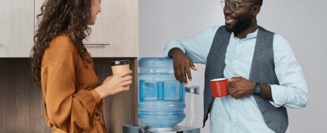two coworkers chatting by the water dispenser