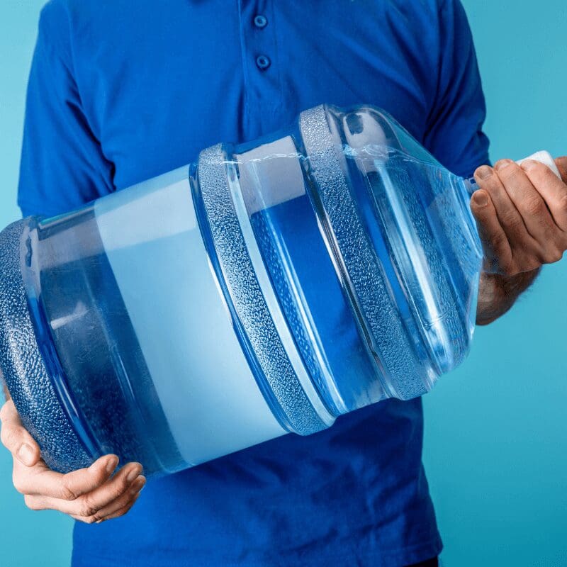 cropped-view-of-courier-5 gallon jug employee holding 5-gallon water jug