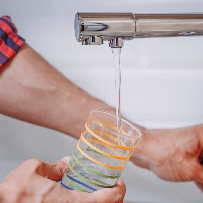 man-pouring-glass-of-clean drinking water-from-tap man using RO faucet to fill drinking glass
