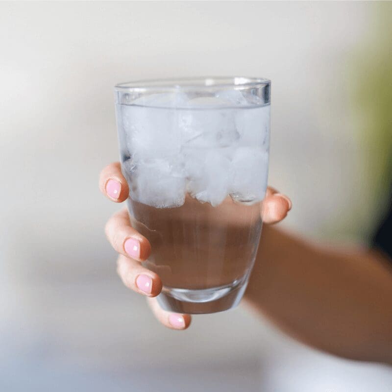 hand holding glass of ice water