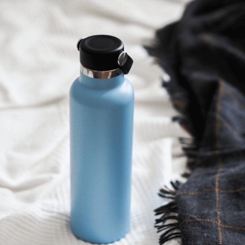 reusable blue water bottle on blanket